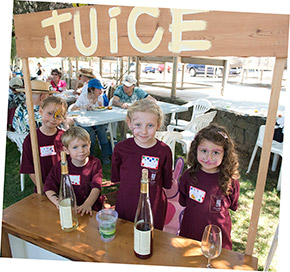 Kids pouring samples of juice at their juice stand during Navarro's annual barrel tasting party
