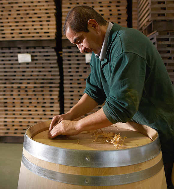 A man from Billon Cooperage assembles a wooden barrel