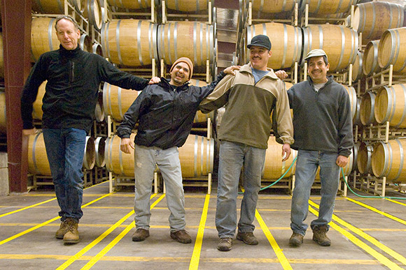 Jim, Ulises, Alfredo and Manual, winery employees, leaning on each other.