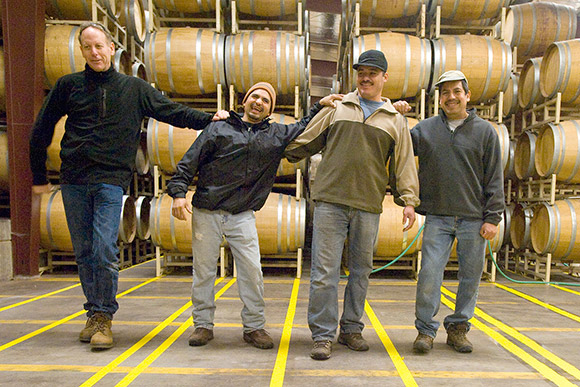 Jim, Ulises, Alfredo and Manual, winery employees, leaning on each other.
