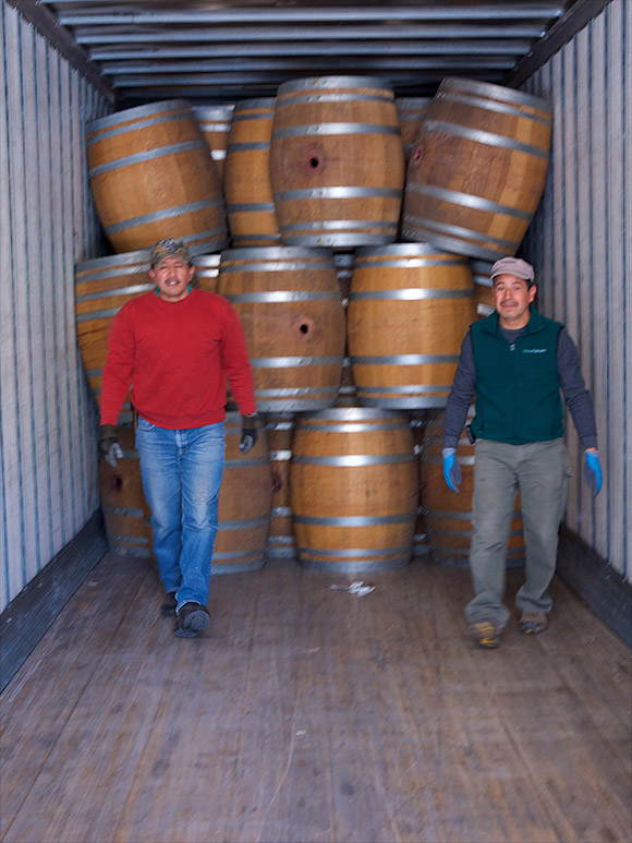 Manuel and Jesus inside a truck stacking and saying goodbye to six-year-old barrels that we've sold