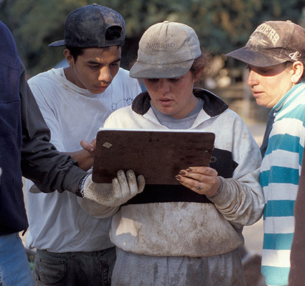 Vineyard pickers inspecting tally sheet.