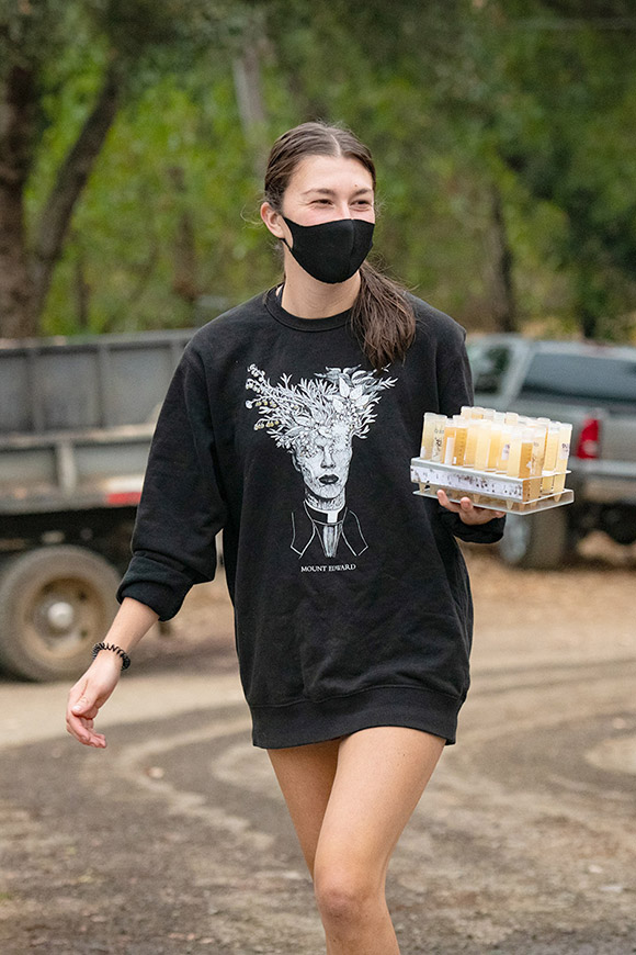 Haley, a winery intern in 2020, carrying tubes of fermenting juice from each of Navarro's oval-fermenting vineyard lots.