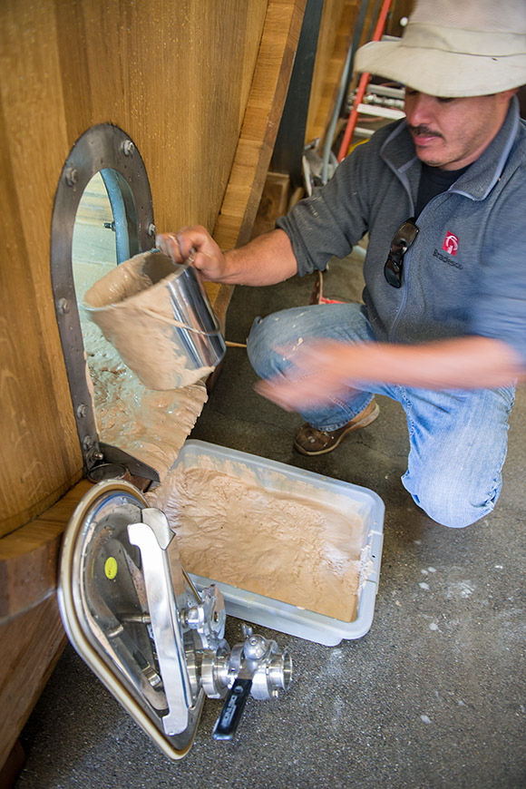 Alfredo removing the dead yeast from an oval.